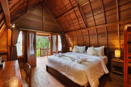 a bedroom with a large bed in a wooden room at Bunut Bungalow in Nusa Penida