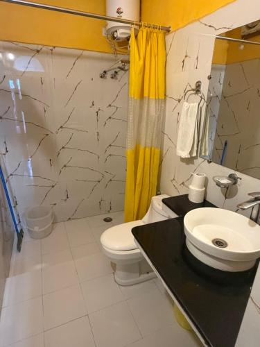 a bathroom with a toilet and a sink at Seventh Heaven Inn Rishikesh in Rishīkesh