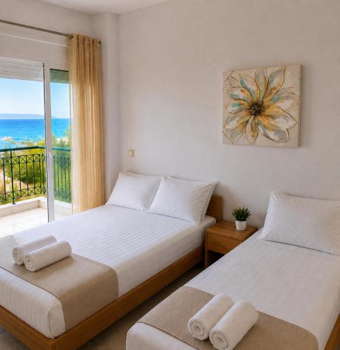 two beds in a bedroom with a view of the ocean at E&M Villa Sea View II in Polychrono
