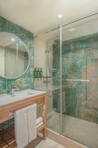 a bathroom with a shower with a sink and a glass shower stall at Castrum Hotel Székesfehérvár in Székesfehérvár