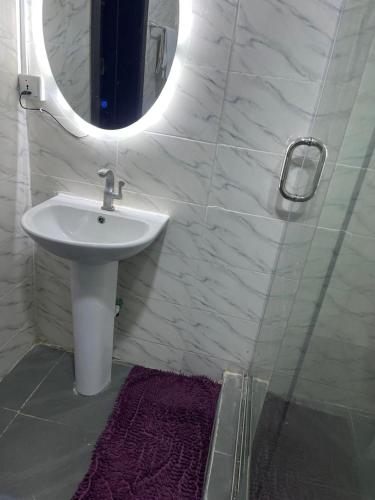 a bathroom with a sink and a mirror at PrimeNest Apartment in Lekki