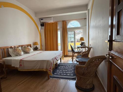 a bedroom with a bed and a table and chairs at Seventh Heaven Inn Rishikesh in Rishīkesh