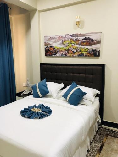 a bedroom with a large bed with blue and white pillows at Diary Hotel in Dar es Salaam