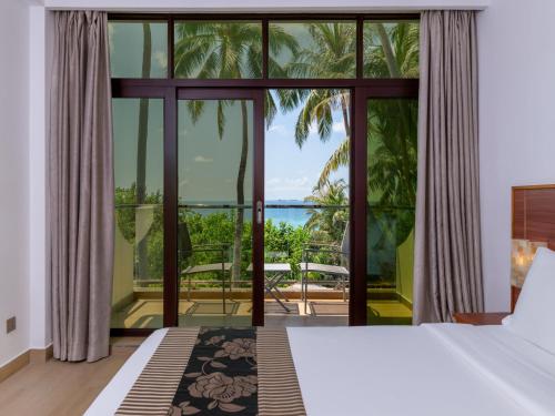 a bedroom with a view of the ocean at Kaani Beach Hotel - Stay 3 Nights and Save 20 Percent on Spa and 10 Percent on Dining Until 31 October 2026 in Maafushi