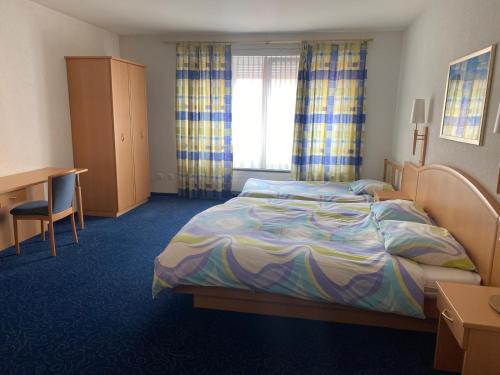 a hotel room with a bed and a desk at My Home Location in La Chaux-de-Fonds