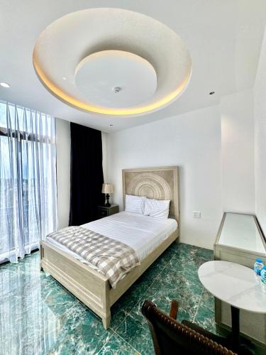 a bedroom with a large bed with a large ceiling at EuroDana Palace Hotel in Danang