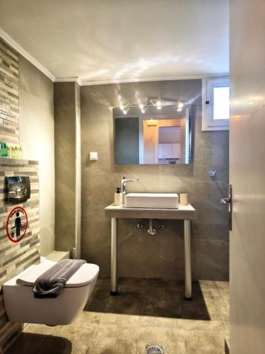 a bathroom with a sink and a toilet at Elite Suites in Afitos