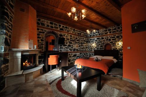a bedroom with a fireplace and a bed and a table at Enastron in Palaios Agios Athanasios