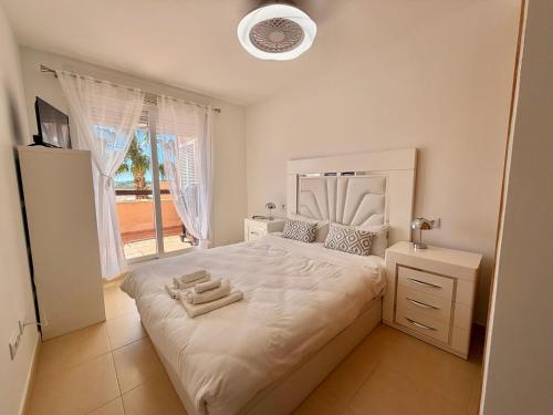 a bedroom with a large bed with towels on it at Condado de Alhama La Isla 11SV2F in El Romero