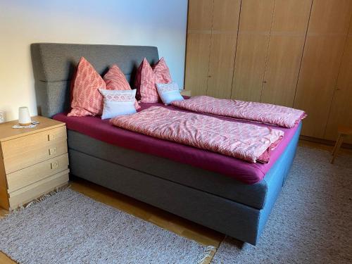 a bedroom with a bed with pink and purple sheets at Haus Margret in Mellau