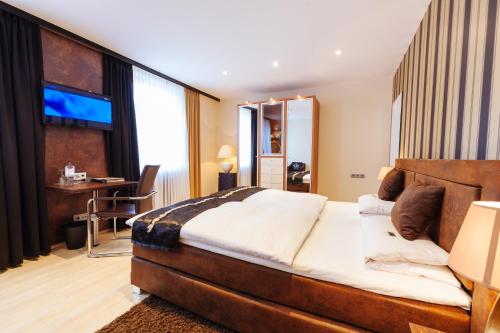 a hotel room with a large bed and a desk at Akzent Hotel Tietmeyer & Cross Side in Schöppingen