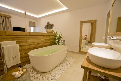 a bathroom with a large white tub and a sink at Thalassa boutique hotel-Adults only in Platis Gialos
