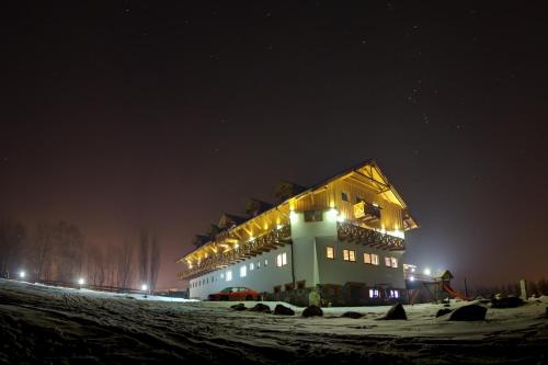 a large building in the snow at night at Rezidence u Jezera in Jeseník