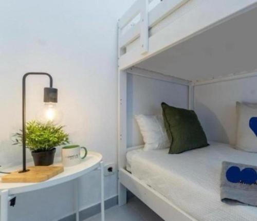 a bedroom with a white bunk bed with a plant at Acuario I RR18 in La Pineda