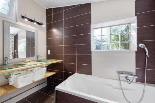 a bathroom with a tub and a sink and a mirror at L'Estran qu'Île - Proche plages in LʼÎle-dʼOlonne