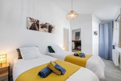 two beds in a room with white and yellow at L'Estran qu'Île - Proche plages in LʼÎle-dʼOlonne