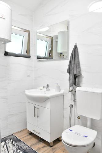 a white bathroom with a sink and a toilet at Family Private House w Garden & Gazebo 10 Guests in Sarajevo