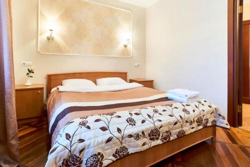 a bedroom with a bed with a brown and white blanket at Home Hotel Apartments on Kontraktova Ploshcha in Kyiv