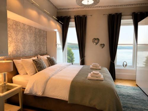 a bedroom with a large bed with two towels on it at Harbour View - Waterfront Retreat, Rothesay in Rothesay