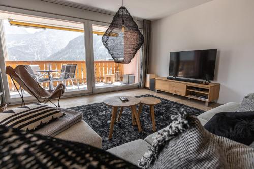 a living room with a couch and a television at Amselfluh in Arosa