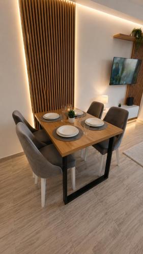 a wooden table with chairs and a dining room at Apartman Centar Paracin in Paraćin