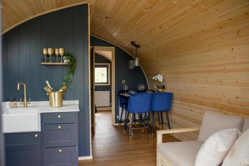 a kitchen and living room with a table and blue chairs at Calmwater Hideaway in New Hey