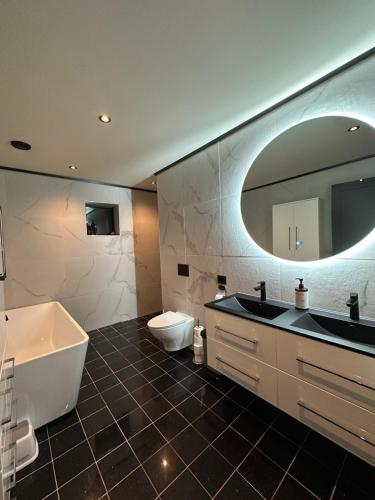 a bathroom with a tub and a sink and a toilet at Olden house fjord and sunset in Stryn
