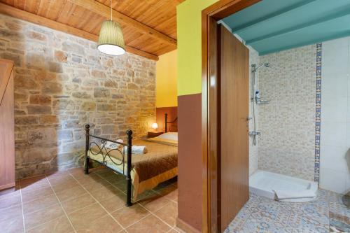 a bathroom with a bed and a shower in a room at Akros Oreon, Omalos Studio in Káto Sími