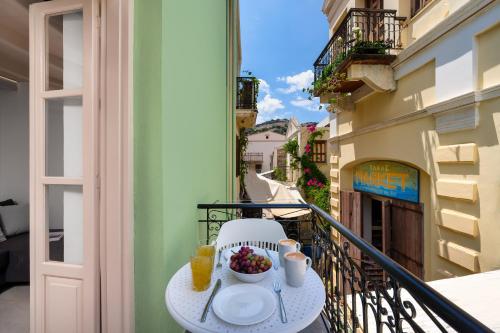 a table with a bowl of fruit on a balcony at Symi Duo in Symi