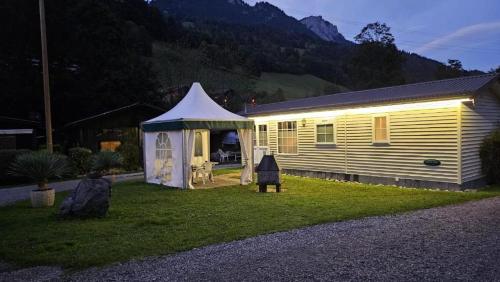ein kleines Haus mit einem Zelt im Hof in der Unterkunft Mobilehome in Weissenburg