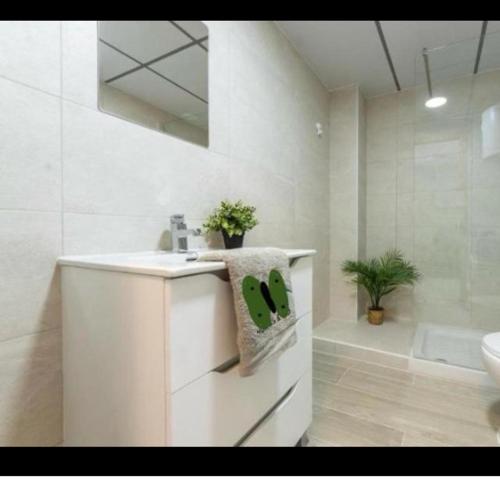 a white bathroom with a sink and a bath tub at Acuario I RR18 in La Pineda