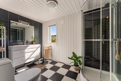 a bathroom with a black and white checkered floor at Lofoten Oceanfront - Privat Pier & Beach in Vestvågøya
