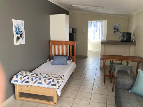 a room with a bed and a table and a couch at 51 on Parfitt in Bloemfontein