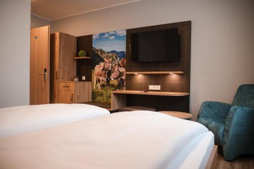 a hotel room with two beds and a tv at Gasthaus Stroh in Buchholz