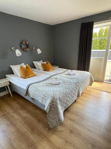 a bedroom with a large bed with orange pillows at Kaptenshuset B&B och Hotell in Kivik