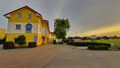 a yellow building with a sign on the side of it at Hotelik MOSiR Reda in Reda