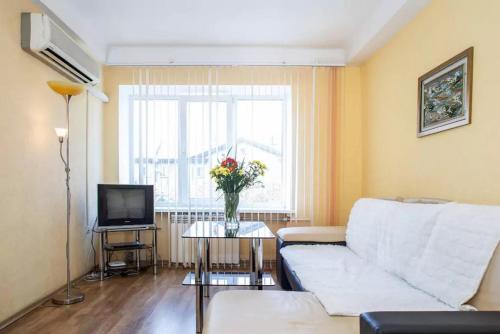 a living room with a white couch and a television at Apartment on Sobornyi Avenue in Zaporozhye