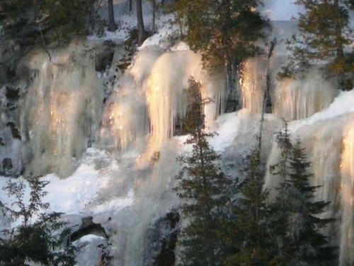 a painting of a waterfall with snow and trees at Kan-à-Mouche Pourvoirie Auberge et Chalets in Saint-Michel-des-Saints