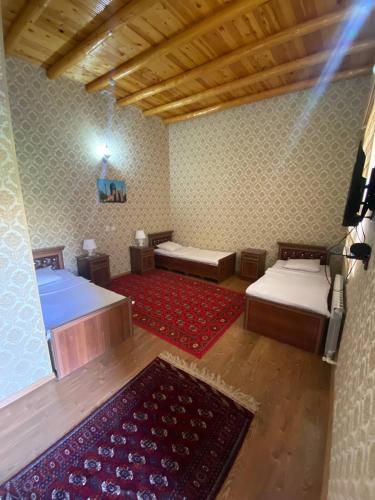 a room with two beds and a red rug at TURKMAN's PALACE in Urganch