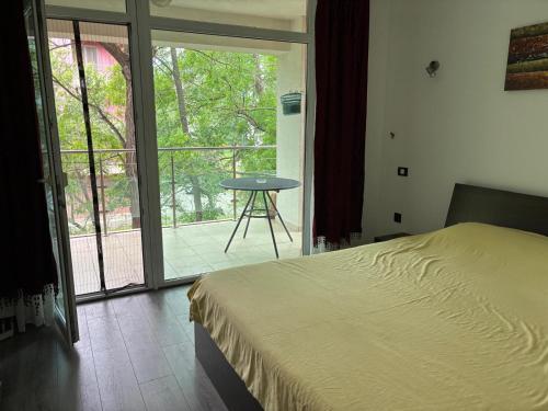 a bedroom with a bed and a balcony with a table at apartament PIANO in Mamaia
