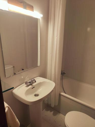 a bathroom with a sink and a mirror and a tub at La Posada de San Martin in San Martín del Castañar