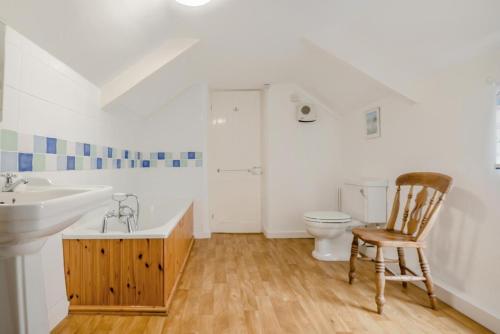 a bathroom with a sink and a toilet and a chair at 3 Bed in Polruan oc-pc049 in Fowey