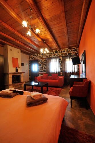a bedroom with a large bed and a living room at Enastron in Palaios Agios Athanasios