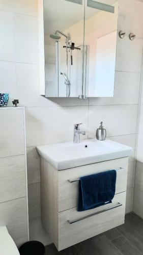 a white bathroom with a sink and a mirror at Ferienwohnung Klosterblick in Homburg