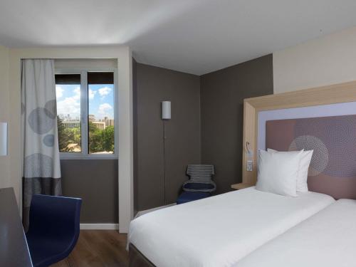 a hotel room with two beds and a window at Novotel Dakar in Dakar