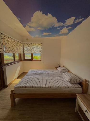 a bedroom with a bed with a painted ceiling at Vlasic Odmor - Villa Wellnes & spa in Vlasic