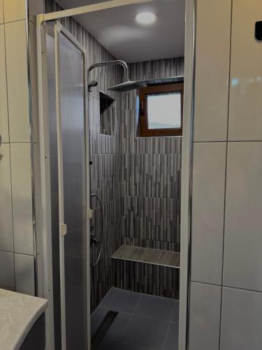 a walk in shower with a glass door in a bathroom at Vlasic Odmor - Villa Wellnes & spa in Vlasic