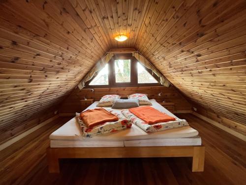 two beds in a wooden room with a window at Gemütliches Blockhaus in Harsefeld
