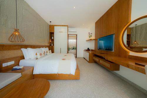 a hotel room with a bed and a tv at Lomo Boutique Hotel & Villas, Uluwatu in Uluwatu