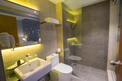 a bathroom with a sink and a toilet and a shower at Redpine Hotel in Skudai